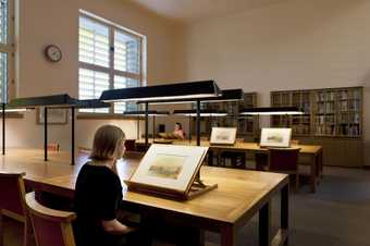 Visitors viewing watercolours at large desks in Tate's Prints and Drawings Room